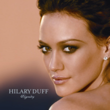 The face and shoulders of a young woman looking over her left shoulder. She has brown hair and wears small crystal earrings. To the left of her image, the words "Hilary Duff" are written in silver, capital letters, with "Dignity" in silver, italic, cursive letters below that.