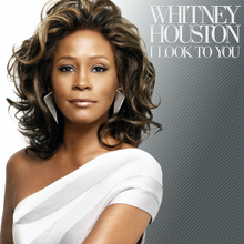 From left to right, the background fades from white to teal. In the foreground, slightly off-center stands an Afro-American woman in a white over-one shoulder dress. She is smiling and her long hair is flowing. In the right hand corner is her the name of the artist, Whitney Houston followed by the title of the album, I Look to You in a simple white font.