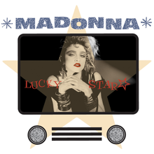 Madonna with her hands folded and looking towards the front. She has unkempt hair, wears heavy makeup, and a number of metallic jewelry on her neck and hands.