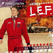 Ferry Corsten, seen wearing a racing suit, leaves out of a car which is seen burning on fire.