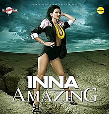 Inna wearing a black coat and leotard with high heels and a yellow necklace.