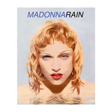 A close-up image of Madonna submerged with her head above water and her hands over her breasts.