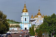 Photograph of the monastery's front section, with the rebuilt bell tower in the foreground