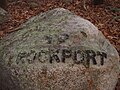 Babson Boulder near the MBTA tracks indicating the direction of Rockport