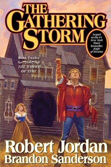 The front cover showing Rand al'Thor with Min Farshaw in the background, in front of a building with a burnt-out hole in the center. The title is justified middle and top in stylized letters. Authors names are middle and bottom, with Jordan's in larger letters above Sanderson's.