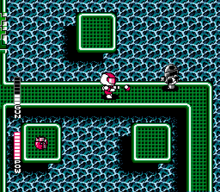 A person in a suit is on a green bridge over water. A robot is shooting at this person from the right. There is a red power-up item on an island next to the bridge.