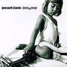 In a monochrome image, a child look below while holding a pistol on the right hand with a set of crayons on the background. The word "Jeremy" has the second "e" lowered.