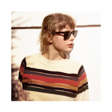 Taylor Swift standing under the sunlight, looking to her left, wearing sunglasses and a horizontally stripped T-shirt.