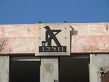 סמל המפעל המתנוסס מעל בניין המנהלה הנטוש בשטח המפעל ההיסטורי בחיפה