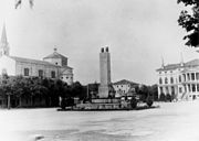 Noventa Vicentina in una foto d'epoca. Vista della Piazza IV Novembre: a sinistra il Duomo, al centro la fontana monumento dei caduti e a destra Villa Barbarigo