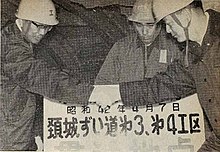 1967年（昭和42年）4月7日、第3工区と第4工区の貫通点にて握手する国鉄岐阜工事局長高橋克男（右）と同糸魚川出張所長朝倉隆（左）