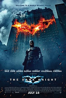 In the background, a building burns in the outline of a bat symbol. In front of the building, Batman looms. Above reads the tagline: "Welcome to a world without rules." Below is the film's logo and the credits.