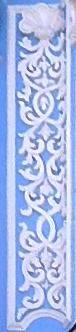 Stucco arabesques in white on a pale blue background on the Bell Tower of the Far Caves.