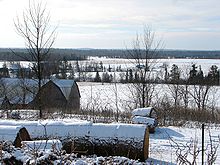 Photo of farm buildings and fields covered in snow