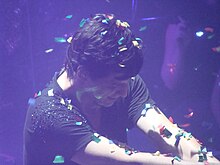 Singer in blue light, with falling confetti