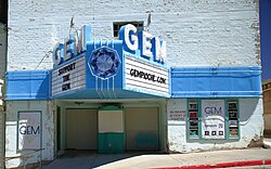 White building with a large blue marquee sticking out over two doors