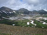 Flat valley or caldera with patches of snow.