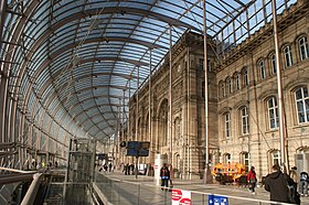 Der Vorplatz des Straßburger Bahnhofs liegt hinter und unter einer gewölbten Glaswand