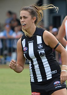 A female athlete with long brown hair in a ponytail