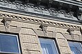 Architectural detail on one of the buildings. Note carved faces over windows.