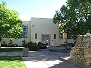 The Art Annex (1926) at UNM, a more abstract Pueblo style building, evokes vigas using stylized ornamentation