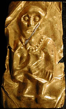 A goldleaf depicting a man with large eyes who holds his hands on his chest