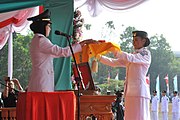 Pembawa baki bendera menerima bendera merah putih dari Walikota Tangerang Selatan Airin Rachmi Diany selaku inspektur upacara untuk dikibarkan (th 2012)