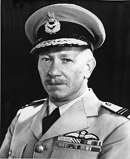 Head-and-shoulders portrait of a caucasian man in light-coloured uniform with peaked cap and pilot's wings on left-breast pocket