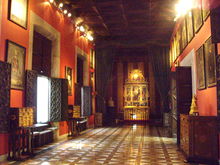 view down a room with windows to the left ending in a small chapel