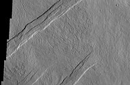 Oti Fossae, as seen by THEMIS. These parallel graben are found on the northeastern side of Arsia Mons; they are in line with the NE/SW trend of the three volcanoes in Tharsis.