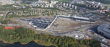 Der Bahnhof Hagalund im Jahr 2012, dahinter Ulriksdal und Råstahem, rechts die Friends Arena (Blick nach Norden)