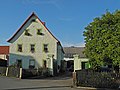 Wohnstallhaus und Scheune eines Bauernhofes, dazu Hofmauer mit Toreinfahrt und Pforte