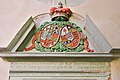 Barocker Portalschmuck an der Kirche: Allianzwappen des Jahres 1714 des Grafenpaares Wilhelm Moritz zu Solms-Braunfels und Magdalene Sophie, einer geborenen Landgräfin zu Hessen-Homburg