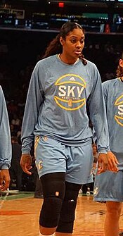 Tall woman walking towards camera wearing a Sky warmup suit