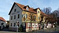 Gasthof „Zum Auer“ (nur Hauptbau an der Straße) mit Holzvorbau, Pflasterung und Gästegarten mit großen Bäumen (Gartendenkmal)