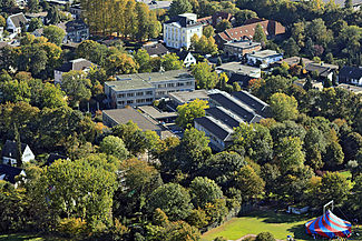 Luftaufnahme des Gymnasiums Filder Benden mit dem Sportplatz rechts unten