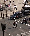 Πεζοί διασταυρώνουν κεντρικό δρόμο σε διάβαση στο Λονδίνο.