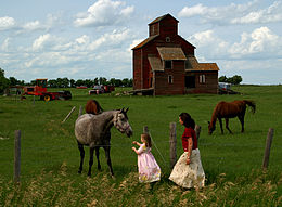 Dua orang gadis dan penaik bijian di sebuah ladang dekat Moose Jaw, Saskatchewan