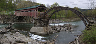 Damage caused by flood waters on the Ottauquechee River to the Taftsville bridge.