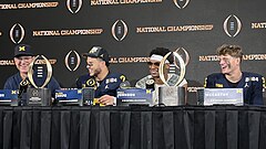 Football players and coaches giving a press conference