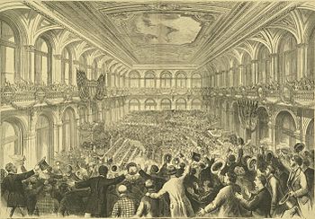 Black-and-white drawing of a vast assembly hall, viewed from the back of a left-side gallery. Far below (barely discernible) other delegates are gathered around the grand stage to our left. Closer, we see the backs of many men in long coats, most standing in excitement, holding or waving their top hats and bowlers.