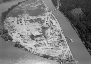 Das Kernkraftwerk Beznau im Bau, neben dem Oberwasserkanal des Wasserkraftwerks Beznau (rechts)