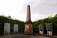 Kriegerdenkmal mit Sandstein-Obelisk im Zentrum und Tafeln zum Gedenken an Gefallene der letzten Kriege