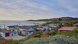 A beachfront street in early morning with several buildings