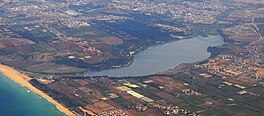 A river flowing through a landscape, with a city visible in the background.