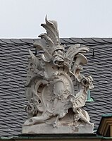 8. Trophäe – Baumstamm, Lanzenfahne, Trompete, Kartusche, Schild, Handspiegel, Rosen. Kopie von Dachfigur 6.