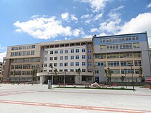 Εξαώροφο εκπαιδευτικό κτίριο με επιγραφή στα σερβικά "Οικονομικό Πανεπιστήμιο"