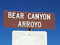 A tautologous sign in Albuquerque, New Mexico, marking the location of a ravine named Arroyo del Oso ('Small-canyon of the Bear') in Spanish, and Bear Canyon in English. The sign's phrasing "Bear Canyon Arroyo" thus means 'Bear Canyon Small-canyon'. The reversed form of the tautology, "Arroyo del Oso Canyon" has also been used, though not on official signage.