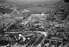 Luchtfoto van Vaaltterrein (links achter het water), rechts de gemeentelijke Gasfabriek met daar tussenin het bedrijventerrein en links vooraan gevangenis Wolvenplein