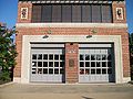 Close up of the old firehouse, showing some horse-drawn apparatus behind the doors